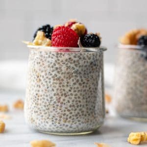 Chia Pudding in a glass jar topped with berries and walnuts.
