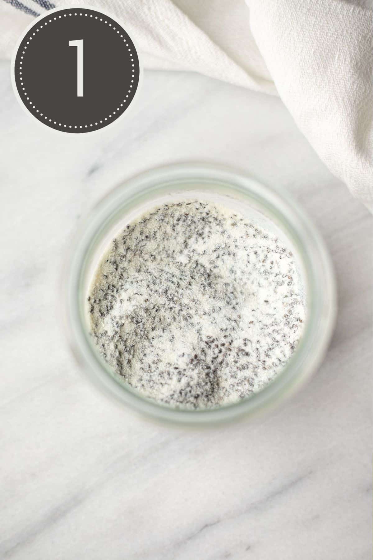 Step one of the recipe showing the dry ingredients of chia seeds and collagen mixed together in a glass jar.