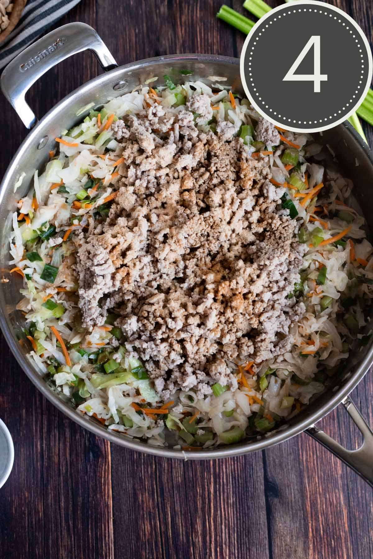 stainless steel pan filled with cooked coleslaw, browned ground turkey, garlic powder, and coconut aminos.