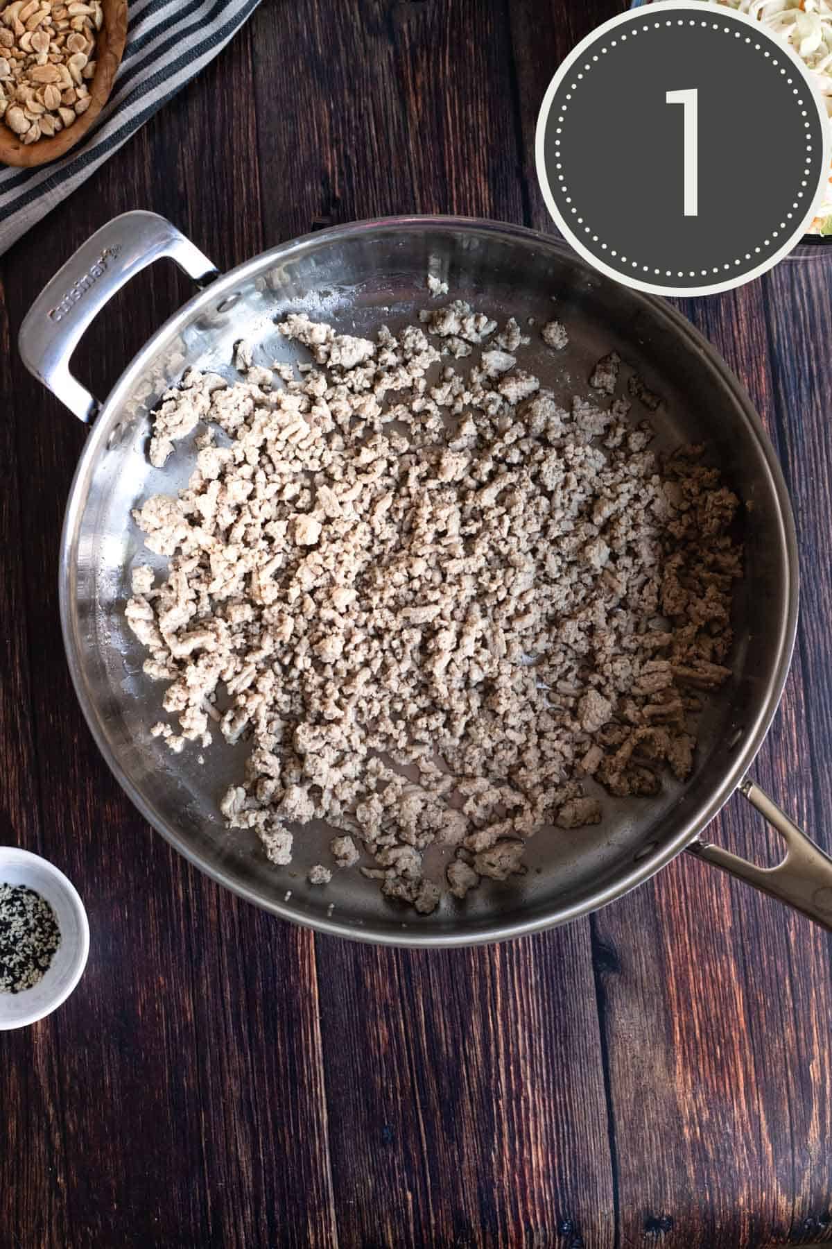 browned ground turkey cooking in a stainless steel pan.