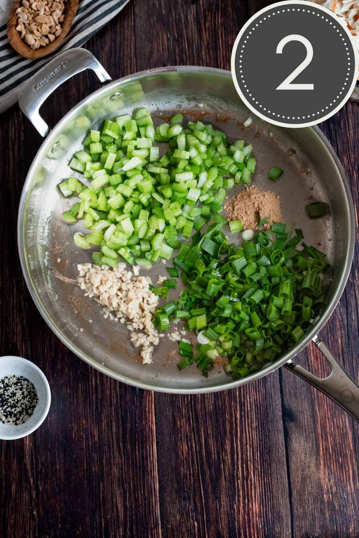 raw celery, green onions, fresh garlic, and ground ginger in a stainless steel pan.